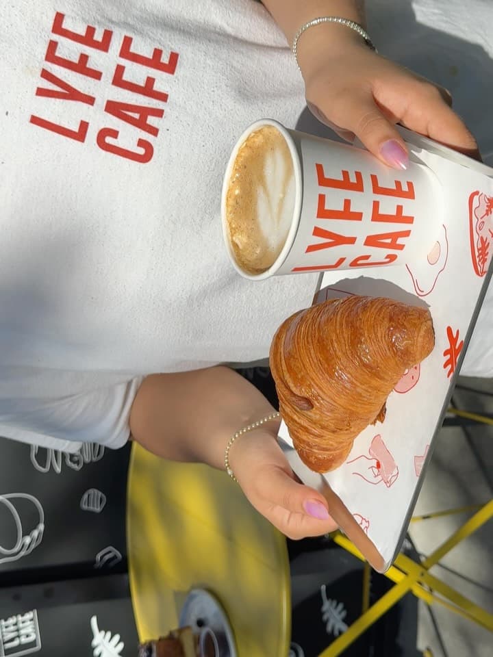 LYFE CAFE branded tee with a fresh latte and croissant